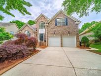 Charming two-story brick home featuring a two-car garage and well-manicured landscaping at 404 Basingdon Ct, Waxhaw, NC 28173