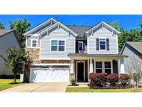 Charming two-story home featuring stone accents, gray siding, and a two-car garage at 413 Hunton Forest Dr, Concord, NC 28027