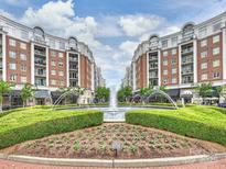 Beautiful Town Square with fountains, landscaping, and shops, surrounded by elegant buildings with balconies under a partly cloudy sky at 4625 Piedmont Row Dr # 701, Charlotte, NC 28210