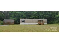 Charming single-story home with siding, a porch and a lush lawn surrounded by mature trees at 544 Bentley Rd, Shelby, NC 28152