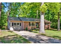 Charming brick home with a metal roof, a well-manicured lawn, and mature trees offering shade and curb appeal at 612 Summerow Rd # Lot 22, Stanley, NC 28164