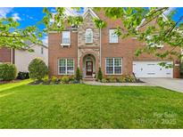 Charming brick two-story home with a well-manicured lawn and attached two car garage at 619 Vega Nw St, Concord, NC 28027
