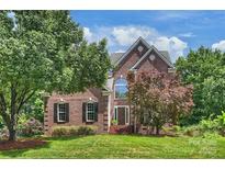 Beautiful brick home with a well-manicured lawn and mature trees at 6723 Joliette Ln, Charlotte, NC 28277