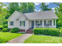 Charming home featuring a welcoming front porch, complemented by lush landscaping and a well-maintained lawn at 735 Shuttles Way, Fort Mill, SC 29715