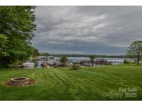 Expansive lake view with a well-manicured lawn, dock, and fire pit, perfect for outdoor entertaining at 7942 Vista View Dr, Sherrills Ford, NC 28673