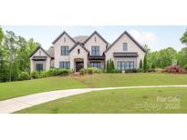 Stunning white brick home with a beautifully landscaped lawn and a long, curved walkway at 1045 Spyglass Ln, Waxhaw, NC 28173