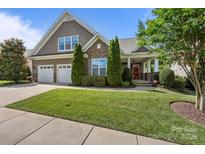 Charming two-story home featuring a beautifully landscaped front yard, three-car garage, and inviting front porch at 11621 Mount Argus Dr, Cornelius, NC 28031