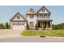 Charming two-story home with a manicured lawn, covered porch, and attached two-car garage at 15431 Cimarron Hills Ln, Charlotte, NC 28278
