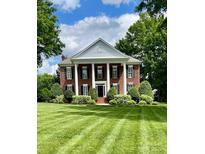 Stately brick home with white columns and manicured lawn creates a grand and inviting curb appeal at 1721 White Pond Ln, Waxhaw, NC 28173