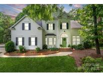 Charming two-story home with a well-manicured lawn, lush landscaping, and a welcoming green front door at 3134 Old Chapel Ln, Charlotte, NC 28210
