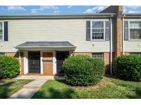 Inviting exterior of a townhome featuring a brick facade, dark doors, and manicured landscaping at 4609 Coronado Dr # N, Charlotte, NC 28212