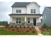 Charming two-story home with stone accents, a covered porch, and professionally landscaped front yard at 9612 Pointer Rd # 59, Huntersville, NC 28078