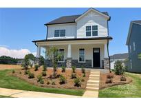 Charming two-story home features a landscaped yard, stone accents, and a welcoming front porch at 9612 Pointer Rd # 59, Huntersville, NC 28078