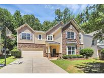 Beautiful two-story home with stone and siding exterior, attached garage, and basketball hoop at 9930 Karras Commons Way, Matthews, NC 28105