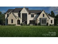 Stunning two-story home showcasing a blend of stone and brickwork, complemented by dark-framed windows and lush green landscaping at Lot 3 Holbrook Rd # 3, Fort Mill, SC 29715