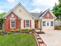 Charming single-Gathering home with a brick and vinyl facade, red shutters, and a well-manicured lawn at 10408 Milstead Ct, Charlotte, NC 28215
