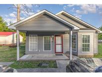 Charming single-story home with gray siding and a covered front porch and red door at 1263 Crawford Rd, Rock Hill, SC 29730