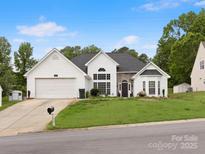 Charming single-Gathering home features a stone accent wall, arched window, and attached two-car garage at 1579 Matthews Dr, Rock Hill, SC 29732