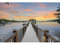 Picturesque waterfront property featuring a private dock with a gazebo, offering stunning sunset views at 17112 Green Dolphin Ln, Cornelius, NC 28031