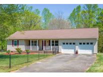 Charming home featuring a cozy front porch, well-maintained lawn, and an attached two car garage at 174 Stewart Acres Dr, Statesville, NC 28677