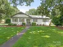 Charming white brick home featuring a beautiful lawn and manicured landscaping at 3615 Champaign St, Charlotte, NC 28210