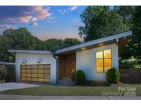 Stylish home showcasing a modern design, glass garage door, and manicured lawn at 4211 Mantle Ct, Charlotte, NC 28205