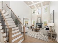 Bright living room with coffered ceilings, fireplace, hardwood floors and large windows providing natural light at 4907 Ardenwoods Dr, Charlotte, NC 28215