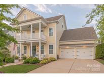 Charming two-story home with a welcoming front porch and a three-car garage at 5250 Meadowcroft Way, Fort Mill, SC 29708