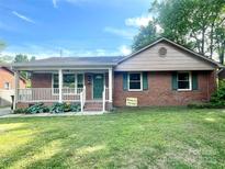 Charming single-story brick home featuring a cozy front porch and well-maintained lawn at 601 Scottsbrook Dr, Charlotte, NC 28213