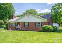 Charming brick home featuring black shutters, a well-manicured lawn, and inviting front porch at 712 2Nd Nw Ave, Conover, NC 28613