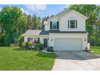 Charming two-story home featuring a well-manicured lawn and an attached two-car garage at 7128 Rock Bass Ct, Concord, NC 28025