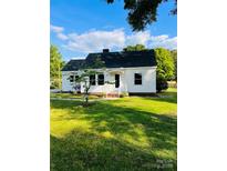 Charming cottage-style home with a well-maintained lawn and traditional architectural details at 716 E Union St, Marshville, NC 28103