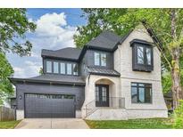 Stunning two-story home featuring a brick and wood exterior, dark trim, and attached two-car garage at 910 Everett Pl, Charlotte, NC 28205