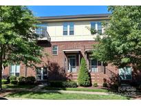Inviting three-story brick home featuring modern design elements, including sleek railings and a well-manicured front lawn at 926 Steel House Blvd, Charlotte, NC 28205