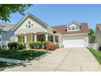 Charming two-story home featuring a well-maintained lawn, inviting front porch and attached two-car garage at 1027 Feather Oak Ln, Matthews, NC 28104