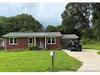 Charming brick home with well-maintained lawn, covered parking, and a welcoming front entrance at 1203 Pamela Dr, Shelby, NC 28150