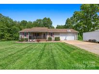 Charming single-story home with a covered porch, two-car garage, and a well-maintained lawn at 130 Helen Dr, Statesville, NC 28625