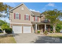 Charming two-story home with stone accents, red shutters, and a two-car garage at 13502 Brandon Trail Dr, Charlotte, NC 28213