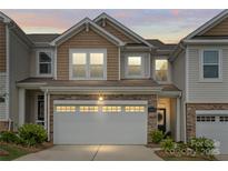 Charming two-story townhome with stone accents and a two-car garage, enhanced by a well-maintained lawn at 15622 Little Bluestem St, Charlotte, NC 28278