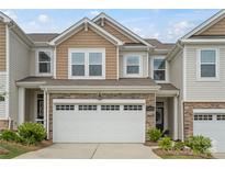 Charming home featuring a two-car garage, stone accents, and a mix of vinyl and shingle siding at 15622 Little Bluestem St, Charlotte, NC 28278