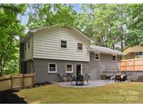 Charming backyard patio with dining and sitting area, perfect for relaxing and entertaining, plus a fenced in yard at 2009 Edgewater Dr, Charlotte, NC 28210