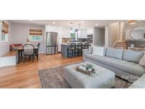 Inviting living room featuring hardwood floors, a gray sofa, and an island kitchen view at 2009 Edgewater Dr, Charlotte, NC 28210