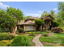 Charming home featuring stone accents, lush landscaping, and a manicured lawn at 2915 Cutter Ct, Waxhaw, NC 28173
