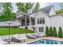 A pristine backyard pool and patio is flanked by lounge seating and manicured landscaping in this relaxing outdoor oasis at 331 Anthony Cir, Charlotte, NC 28211