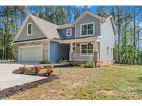 Charming two-story home features a stone-accented garage and inviting front porch at 539 Morrison Farm Rd, Troutman, NC 28166