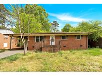 Charming single-story brick home with a cozy front porch and a well-maintained yard at 735 Wilbrown Cir, Charlotte, NC 28217