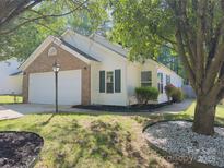 Charming home with white siding, brick accents, a two-car garage, and lush landscaping in a well-maintained yard at 8027 Bristle Ln, Charlotte, NC 28214