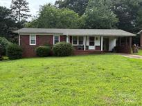 Charming single-story brick home featuring a welcoming front porch and lush green lawn at 908 Mcgowan Rd, Shelby, NC 28150