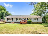 Charming single-story home with wood porch, neutral siding, dark shutters, well-manicured lawn, and mature trees at 10230 Hagers Rd, Huntersville, NC 28078