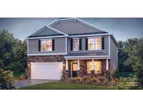 Charming two-story home showcasing stone accents, a manicured lawn, and a welcoming entrance at 11143 Cardinal Creek Ave, Charlotte, NC 28215